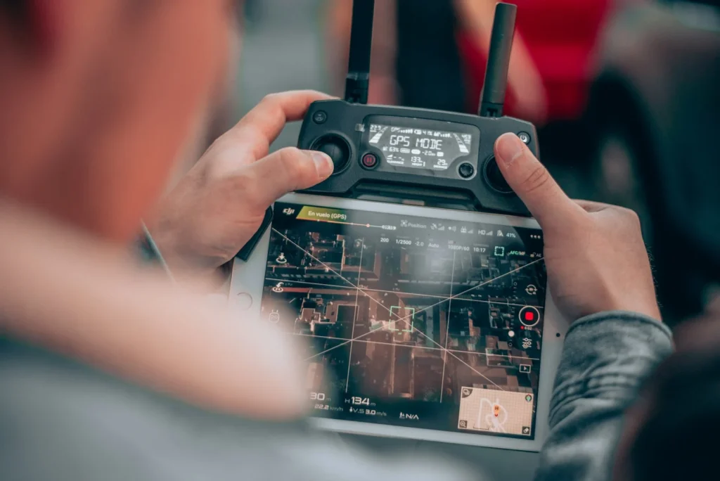 Télépilote contrôlant un drone sur l’écran de sa radiocommande