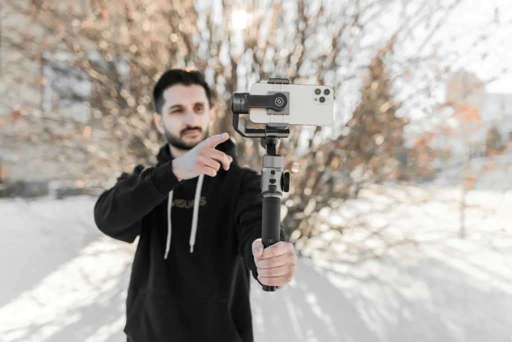 Homme filmant avec un smartphone sur stabilisateur