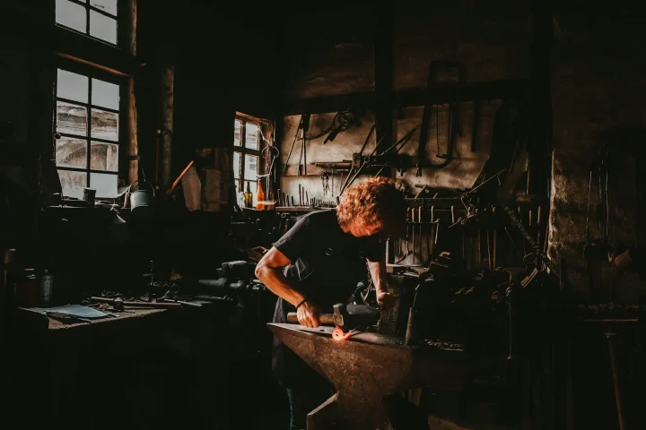 Artisan forgeant le métal sur une enclume