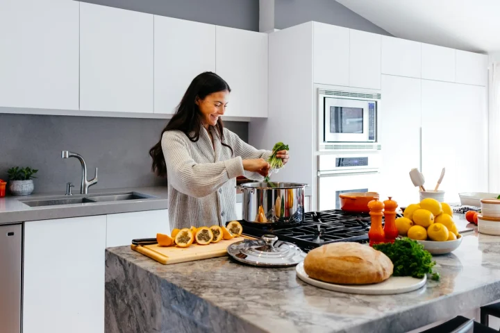 Femme souriante cuisinant dans sa cuisine