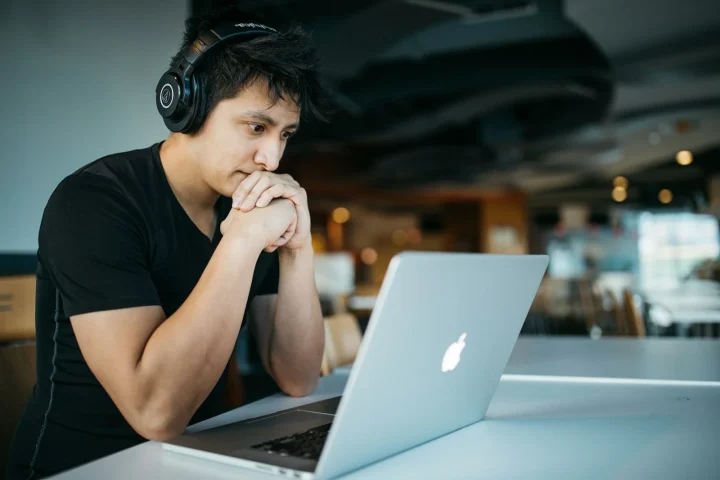 Apprenant suivant un module sur ordinateur avec un casque
