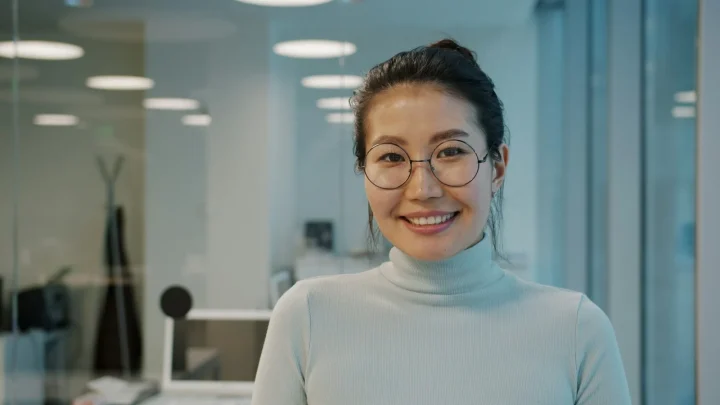 Portrait d’une collaboratrice souriante au bureau